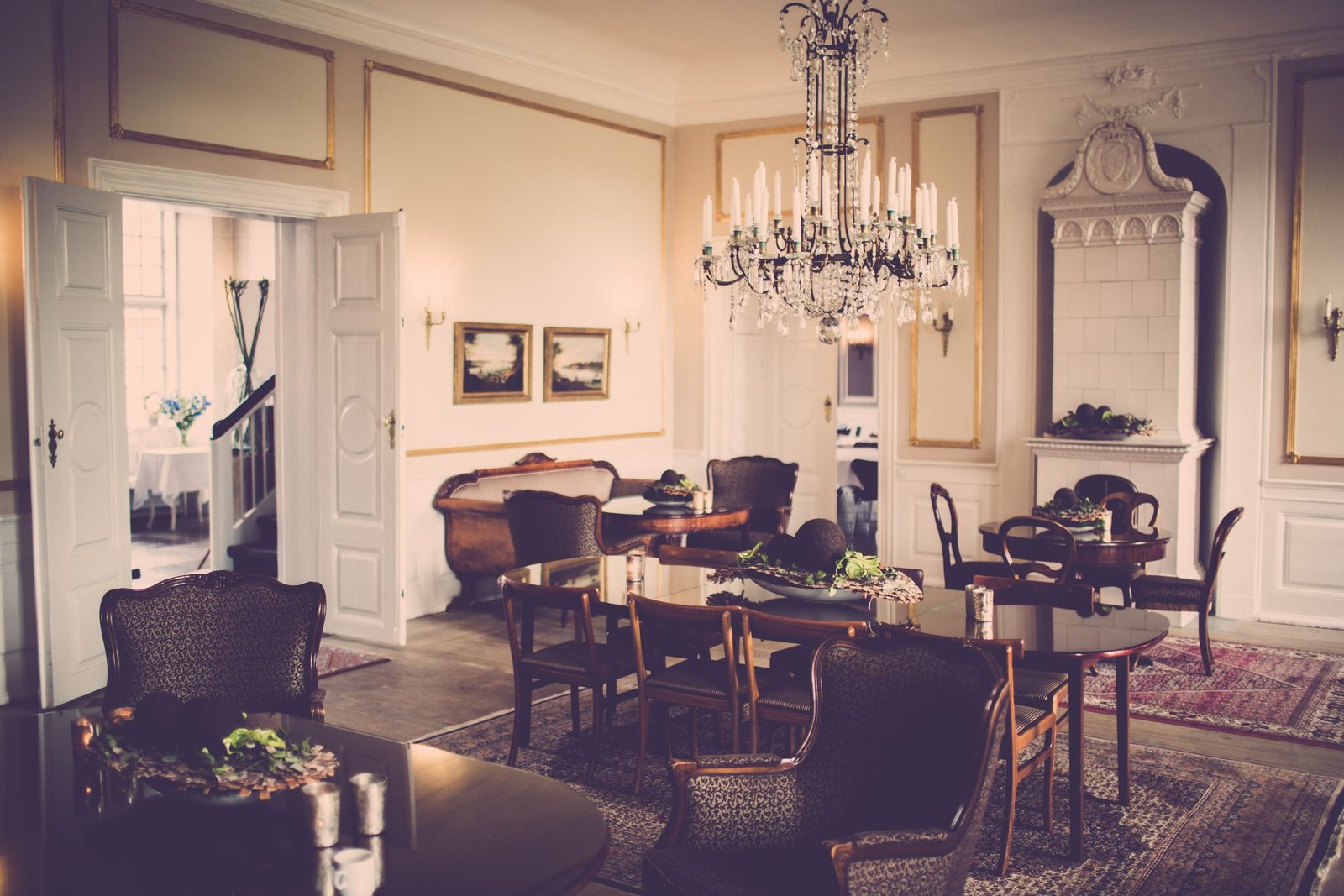 Elegant period dining room with panelled walls, a crystal chandelier and dark timber furniture
